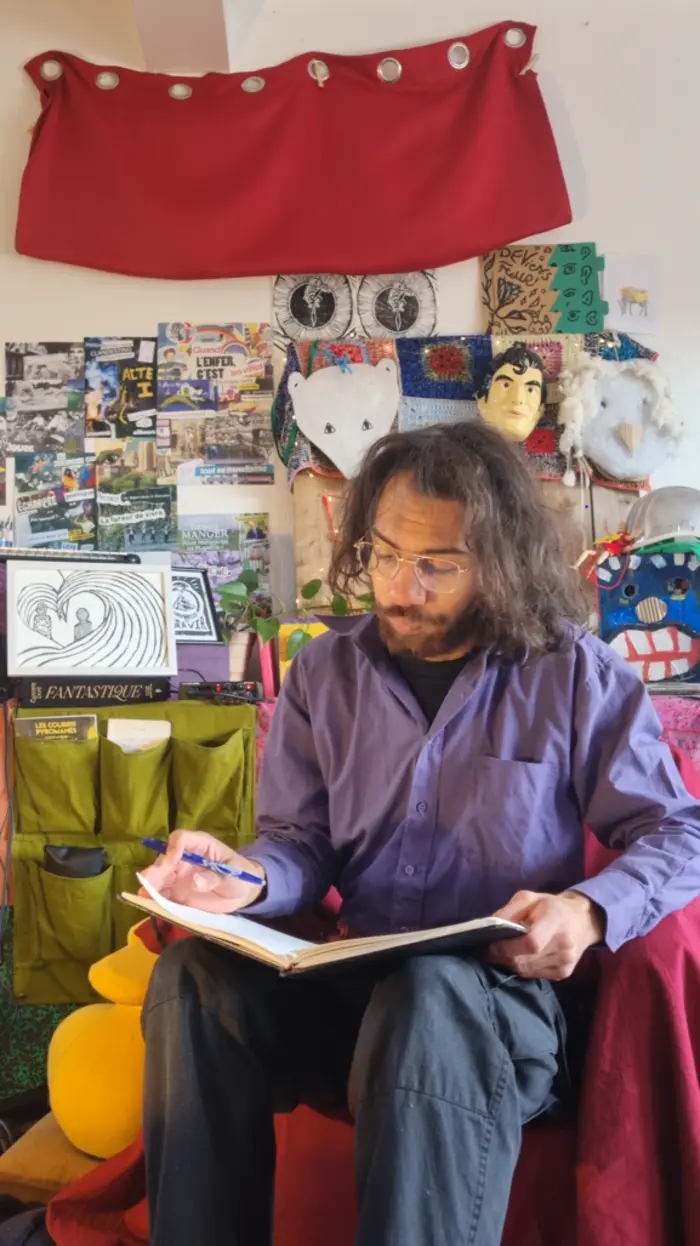 Vie qui écrit dans un carnet, dans un intérieur plein de créations